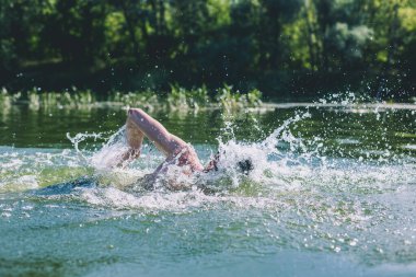 Genç adam nehirde yüzüyor..