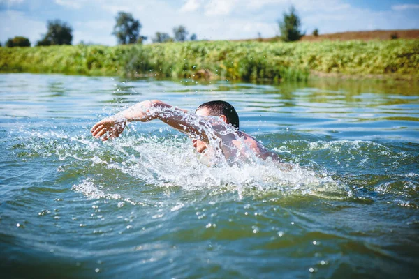 The young man swimming in the river.