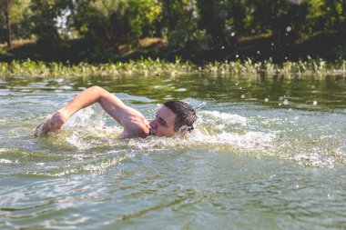 Genç adam nehirde yüzüyor..