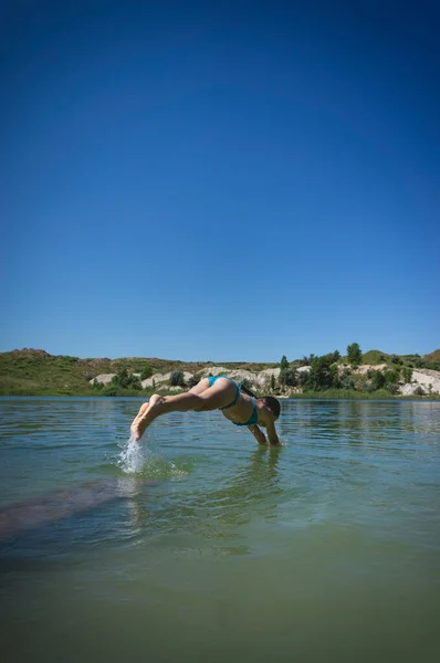 Ένα Χαριτωμένο Κοριτσάκι Μαγιό Πηδάει Στα Καταγάλανα Νερά Μιας Λίμνης — Φωτογραφία Αρχείου