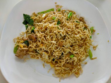 Kızarmış erişte ve bir tabak domuz eti.