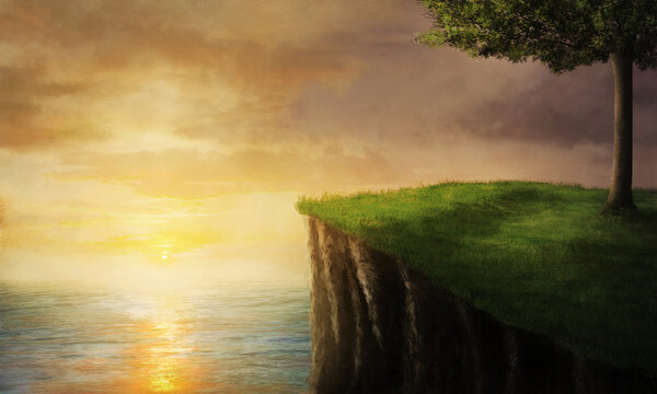 A beautiful sunset at the ocean from a grassy cliff.