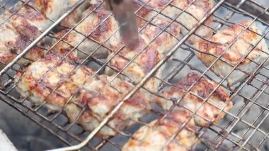 Bıçaklı bir el, ızgaranın hazır olup olmadığını kontrol etmek için eti deliyor.