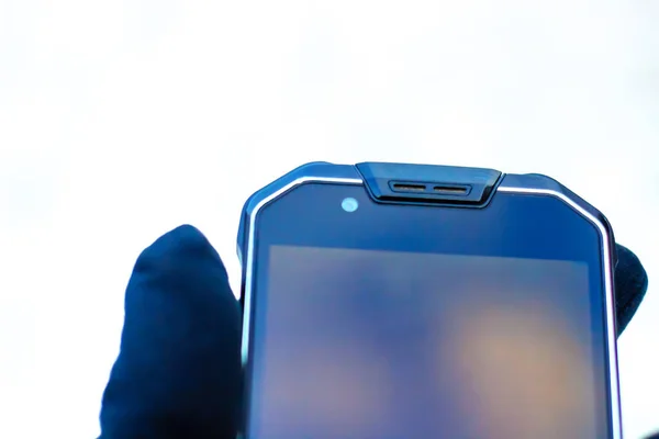 Eldivenli el akıllı telefonu tutar