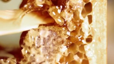 Bal peteğinin bir parçasını beyaz bir bıçakla kesip, bir bıçağın ucuna ip bağlayıp...