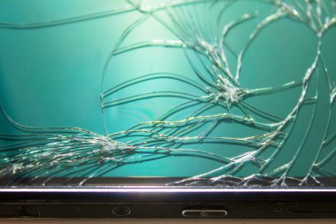 Telefonun camında çatlak, yakın plan, telefonun çerçevesi görünür.