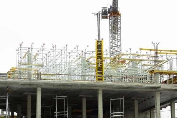 engineering structures of a building under construction, in the background a crane