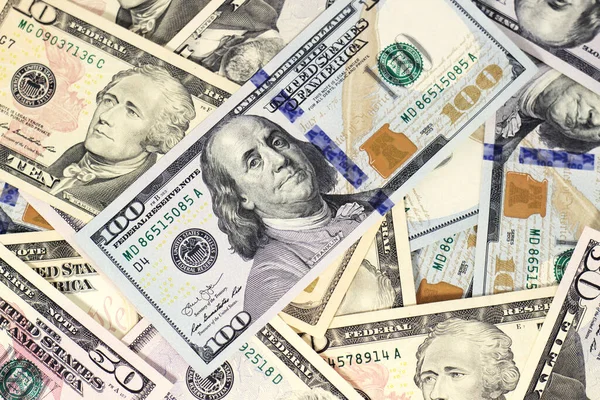 100 dolarlık banknotlar farklı banknotların üzerinde duruyor.