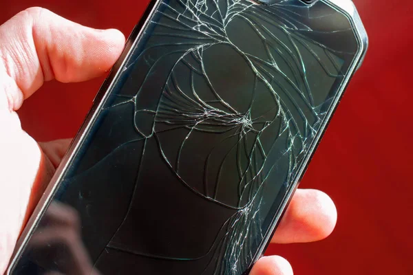 Kırık telefon kırmızı arkaplanda.