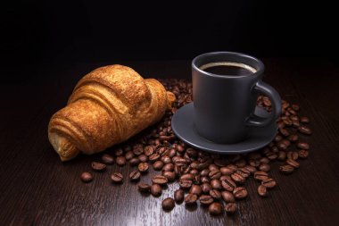 Sıcak espresso, kruvasan ve kahve çekirdekleri.