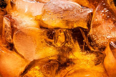 Siyah yansıtıcı yüzeyde buzlu Aperol kokteyli bardağı.