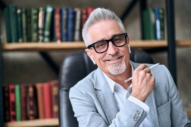 Ofisinde otururken elinde kalem tutan kendine güvenen, gülümseyen bir yetişkinin belini kaldır. İş hayatı kavramı