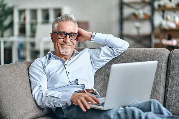 Sonriente Hombre Guapo Acostado Cómodamente Sofá Uso Ordenador Portátil Mientras — Foto de Stock