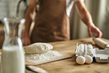 Mutfakta yumurtaları olan bir avuç unla masanın yanında duran adama yaklaş. Pişirme kavramı