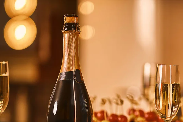 Sluiten Van Glazen Champagne Fles Met Kerstverlichting Achtergrond Vakantie Concept — Stockfoto