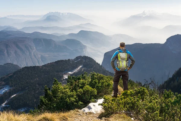 Hombre de senderismo en sendero de montaña. Gran vista sobre las nubes y la niebla. — Foto de Stock