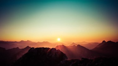 Güzel Günbatımı ya da açık gökyüzü olan dağların tepesinde gün doğumu. Alpler, Allgau, Bavyera, Almanya.