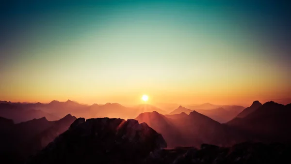 Hermosa puesta de sol o salida del sol sobre las montañas con cielo despejado. Alpes, Allgau, Baviera, Alemania. — Foto de Stock