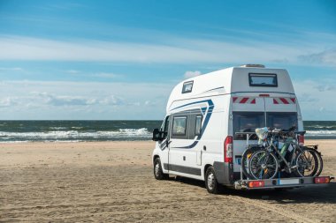 Güneşli bir günde rıhtımdaki kumsalda duran karavan kampı. Romo Bilstrand, Lakolk Strand, Danimarka.
