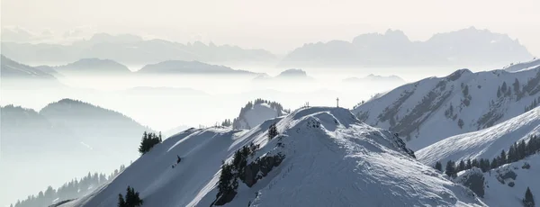 Χιονισμένα Όρη Πανόραμα σε χαμηλή ξαπλωμένη ομίχλη κοιλάδα αντιστροφής. Σιλουέτες ομιχλωδών βουνών. Γραφικό χιονισμένο χειμερινό τοπίο. Άποψη από Stuiben σε Saentis. Alps, Allgau, Βαυαρία, Γερμανία. — Φωτογραφία Αρχείου