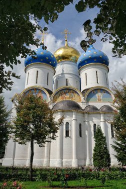 Güzel bir yaz gününde Sergiyev Posad 'daki Kutsal Üçlü St. Sergius Lavra (Manastır) bahçesinde ağaçlar tarafından çerçevelenen beş kubbeli Hüküm Katedrali. SERGİYEV POSAD, MOSCOW REJON, Rusya