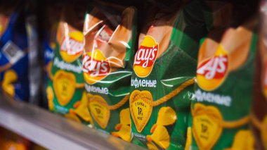 Osipovichi, Belarus - 31.08.2021. Dükkanların raflarında çeşitli etiketli cips paketleri