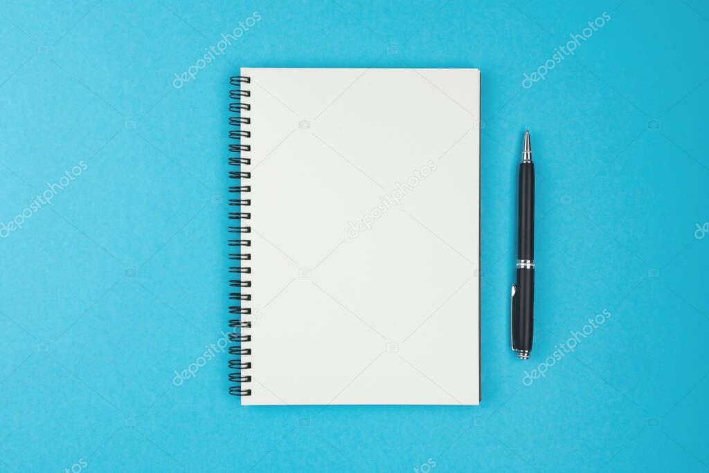 blank spiral bound notebook and ballpoint pen