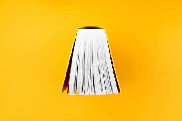 Acima vista de livro grande com capa amarela no fundo laranja — Fotografia de Stock