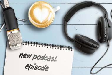 Not defterinde yeni PODCAST Bölüm Mikrofon ve ahşap masada kulaklık