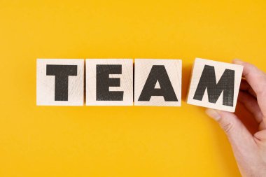 Tahta bloklardaki kelime ekibi turuncu arka plana karşı