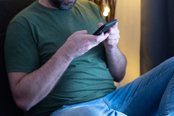 man using smartphone on sofa