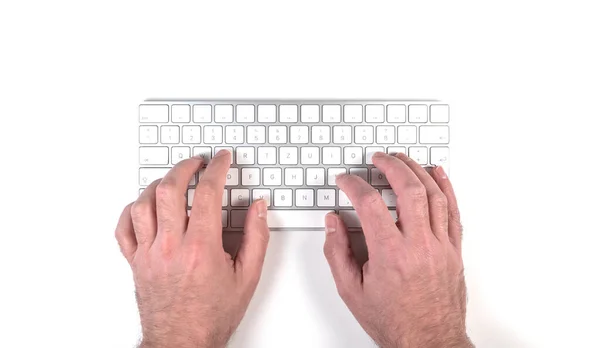 Persoană tastând pe tastatura computerului wireless pe biroul alb — Fotografie, imagine de stoc