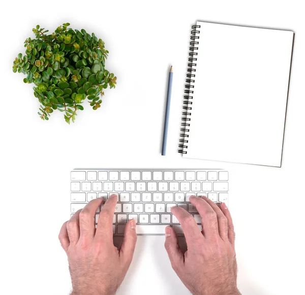 Людина, що вводить на бездротовій клавіатурі комп'ютера на білому столі — стокове фото