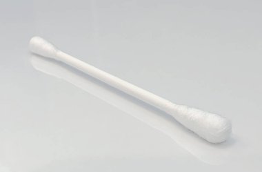 Açık renkli yansıtıcı arkaplanda tek bir pamuk çubuğunun yakın görüntüsü