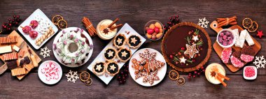 Çeşitli Noel tatlıları ve tatlılar. Üst manzara panoramik masa sahnesi kırsal ahşap arka plan üzerinde. Pasta, çikolatalı turta, kıymalı tart, kurabiye, şekerleme ve eggnog..