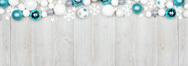 Mavi ve beyaz süslemelerden oluşan bir Noel sınırı. Fotokopi alanı olan gri tahta afiş arkaplanının üzerine üstten aşağı görünüm.