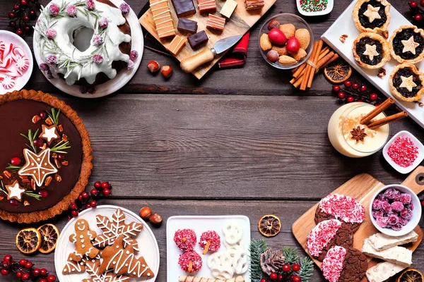 分发圣诞假期甜点和糖果 在木头背景上的顶视图框架 包扎蛋糕 巧克力派 软糖和蛋酒 — 图库照片