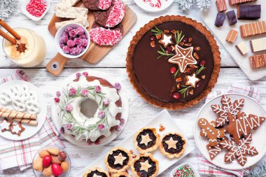 Çeşitli Noel tatlıları ve tatlılar. Beyaz ahşap arka planda en iyi manzara sahnesi. Pasta, çikolatalı turta, kıymalı tart, kurabiye, şekerleme ve eggnog..