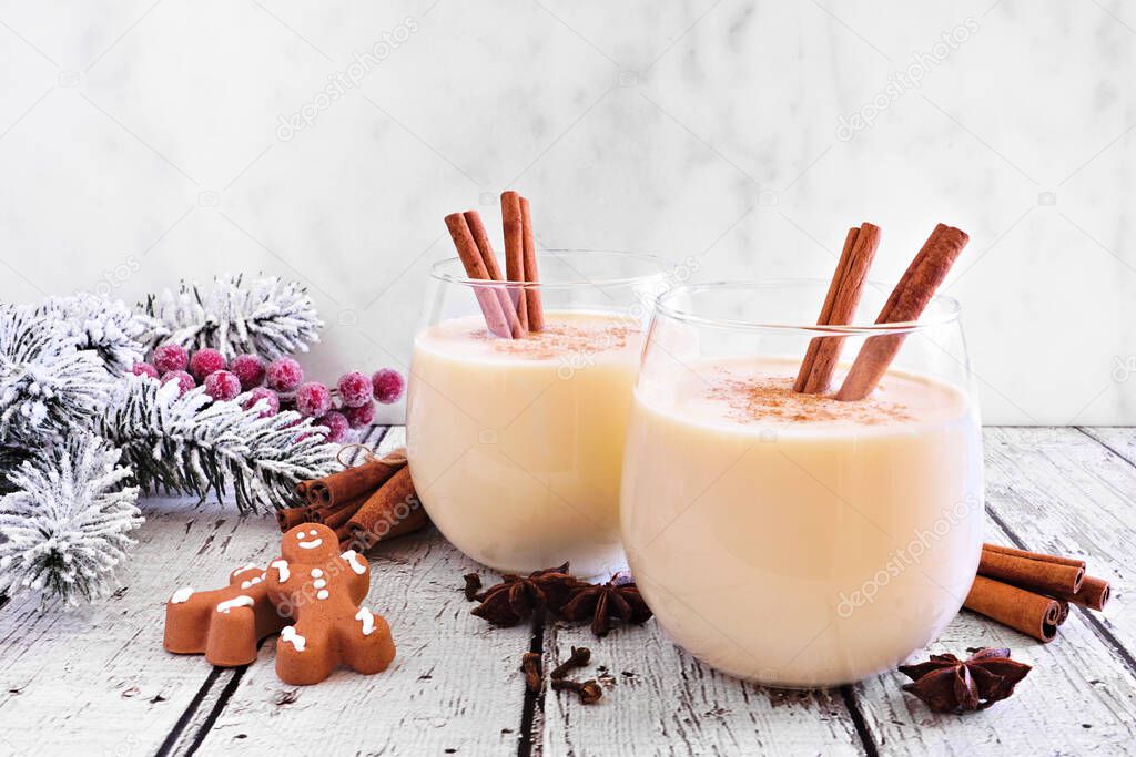  Spiced Christmas eggnog with gingerbread men and holiday decor against a white background
