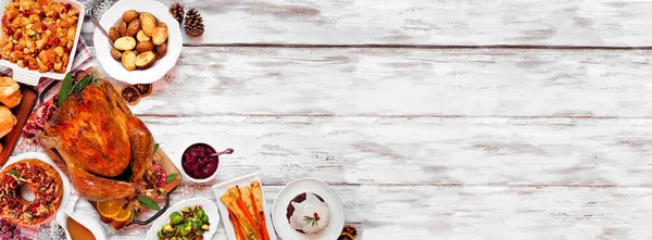 Geleneksel Noel hindisi yemeği. Beyaz ahşap bir arka planda üst köşe kenarı. Hindi, patates ve börek, dolma, meyveli kek ve erikli puding..