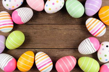 Renkli Paskalya Yumurtası çerçevesi. Kırsal ahşap arka planda tepeden bakıldığında. Boşluğu kopyala.