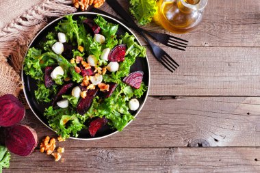 Peynirli ve cevizli sağlıklı lahana ve pancar salatası. Kopya alanı olan ahşap bir arka planda genel görünüm masası sahnesi.