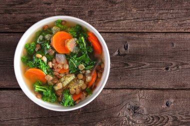 Lahana ve mercimek ile sağlıklı sebze çorbası. Koyu bir ahşap arka planda genel görünüm.