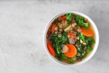 Lahana ve mercimek ile sağlıklı sebze çorbası. Beyaz mermer bir arkaplanda üst görünüm.