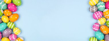 Renkli Paskalya Yumurtası, pastel mavi kağıt kaplama arka plan üzerinde çift kenarlı. Boşluğu kopyala.