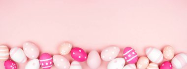 Pembe ve beyaz paskalya yumurtalarının alt kısmı pembe kağıt kaplamalı. Boşluğu kopyala.