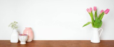 Rafta ev dekorasyonu. Vazolar, çiçekler ve sulu bitkiler. Beyaz bir duvara karşı ahşap bir raf. Kopyalama alanı olan pankart.