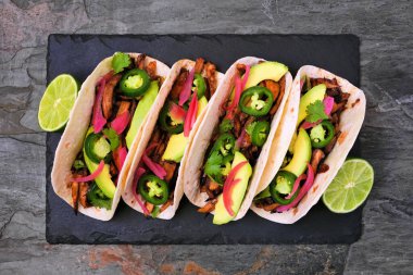 Vejetaryen mantarlı taco. Koyu bir arkaplan üzerinde tepsi görünümü sunuluyor. Sağlıklı beslenme, bitki temelli et ikame konsepti.