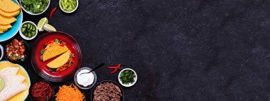 Taco bar köşesi, çeşitli malzemelerle dolu. Koyu renkli afiş arkaplanının üst görüntüsü. Meksika büfesi. Boşluğu kopyala.