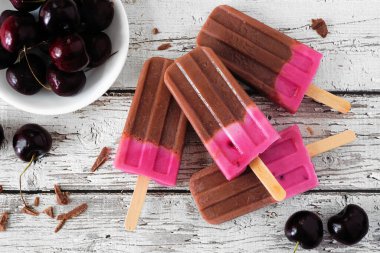 Çikolata ve vişneli dondurma. Kırsal beyaz ahşap arka planda tepedeki masa manzarası.